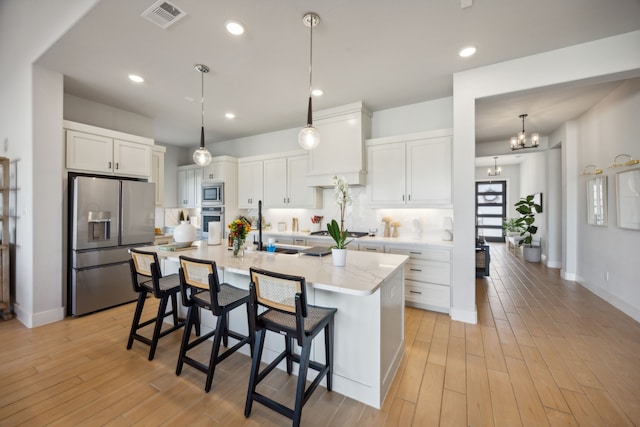 kitchen with light hardwood / wood-style floors, white cabinetry, and appliances with stainless steel finishes