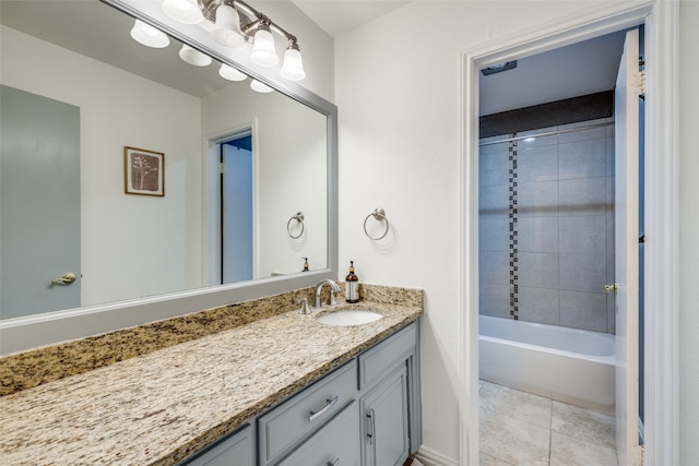 bathroom featuring tile patterned flooring, vanity, and tiled shower / bath combo