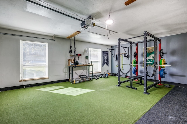 exercise room featuring carpet, golf simulator, a textured ceiling, and a wealth of natural light