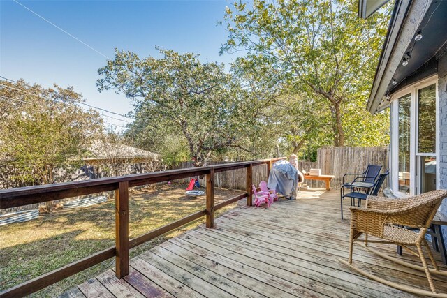 wooden deck featuring a grill