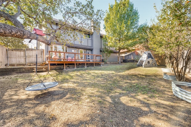 rear view of property featuring a yard and a deck