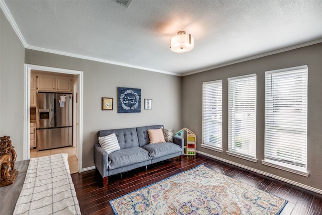 living room featuring crown molding, dark wood-type flooring, and a textured ceiling