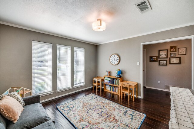 living room with a textured ceiling, ornamental molding, and dark wood-type flooring