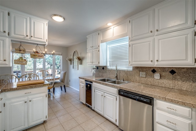 kitchen with stainless steel dishwasher, white cabinetry, and sink