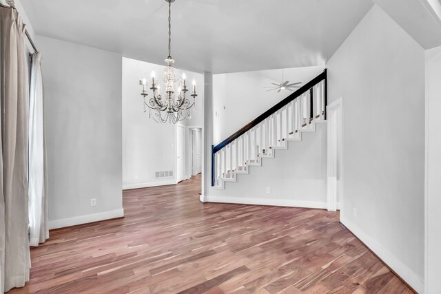 interior space featuring wood-type flooring and ceiling fan with notable chandelier