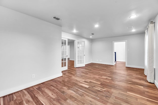 spare room featuring light hardwood / wood-style floors and french doors