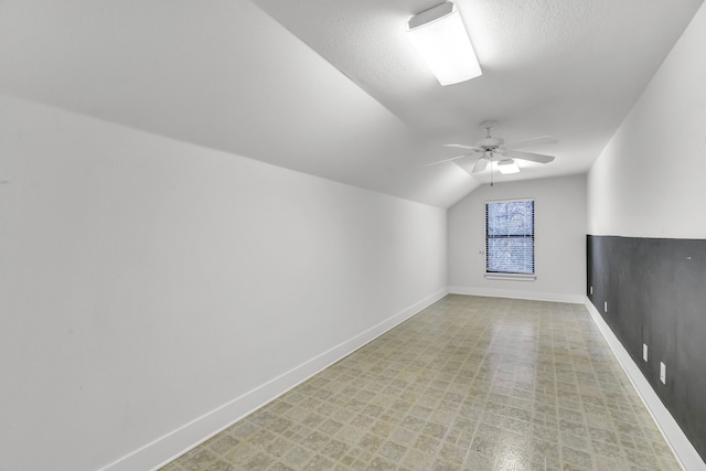 additional living space featuring ceiling fan, lofted ceiling, and a textured ceiling