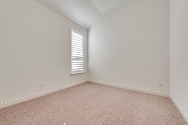 empty room with lofted ceiling and light carpet