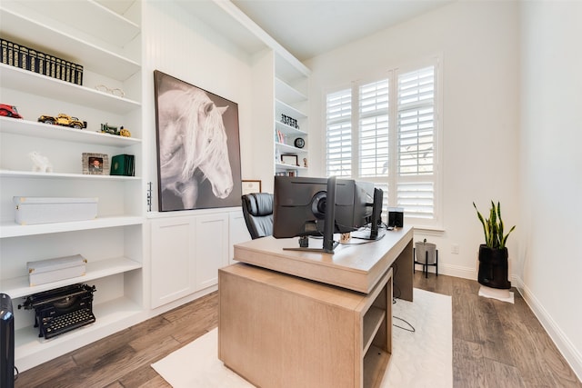 home office with hardwood / wood-style floors and built in features