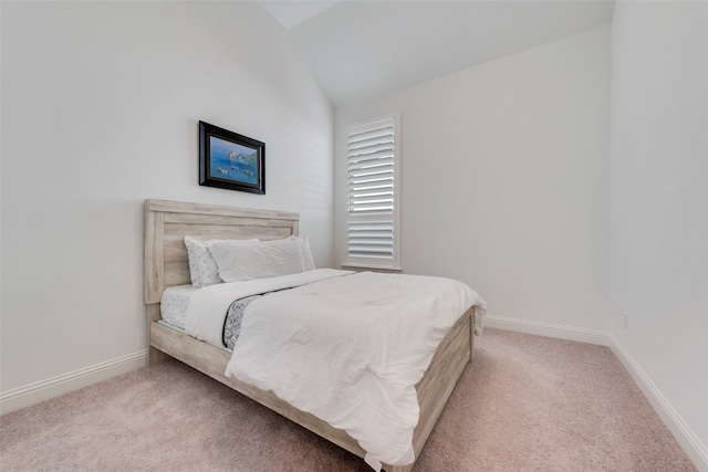 bedroom featuring light colored carpet and lofted ceiling