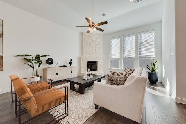 living room with a stone fireplace, ceiling fan, wood-type flooring, and vaulted ceiling