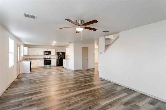 unfurnished living room featuring ceiling fan, hardwood / wood-style floors, and sink