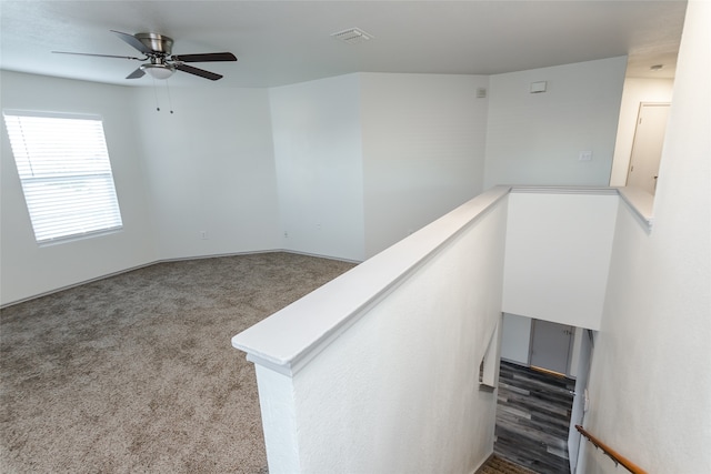 stairs with carpet flooring and ceiling fan