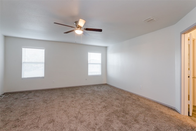 carpeted spare room with ceiling fan