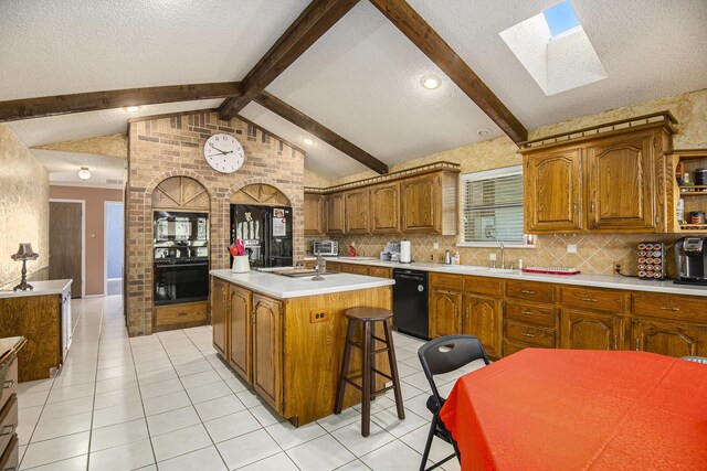 kitchen featuring a center island, lofted ceiling with skylight, black appliances, a kitchen breakfast bar, and tasteful backsplash