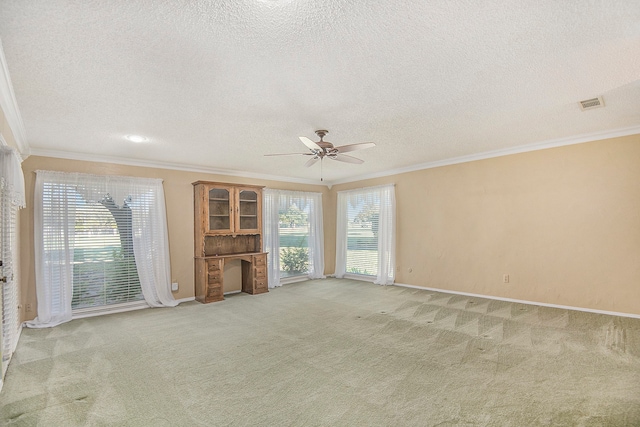 unfurnished living room with a textured ceiling, ceiling fan, light colored carpet, and crown molding