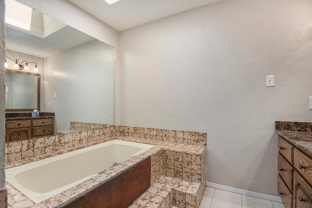 bathroom featuring tile patterned flooring, vanity, a bathtub, and a textured ceiling