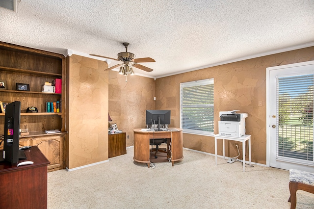 carpeted office featuring ceiling fan, ornamental molding, and a textured ceiling