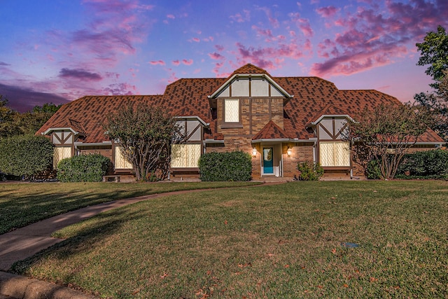 english style home with a lawn