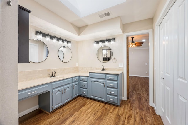 bathroom with hardwood / wood-style flooring, vanity, ornamental molding, and ceiling fan