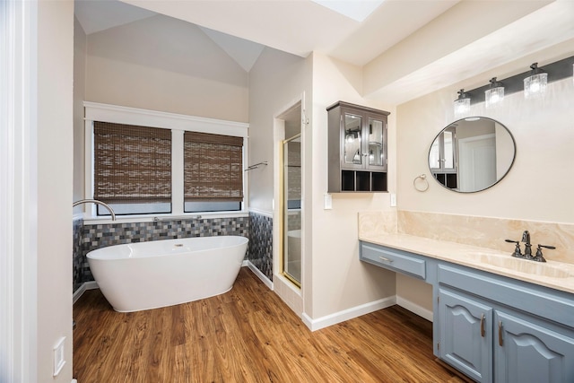 bathroom with lofted ceiling, vanity, shower with separate bathtub, and hardwood / wood-style floors