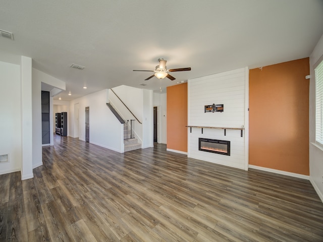 unfurnished living room featuring dark hardwood / wood-style floors, ceiling fan, and a fireplace