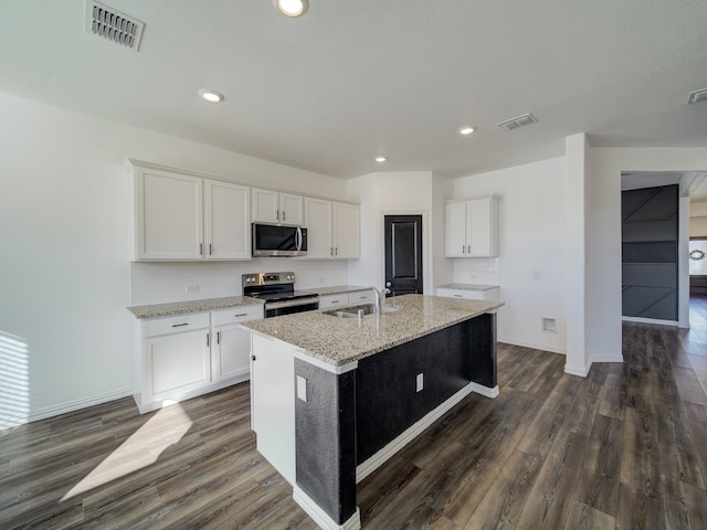 kitchen featuring appliances with stainless steel finishes, dark hardwood / wood-style flooring, sink, a center island with sink, and white cabinetry