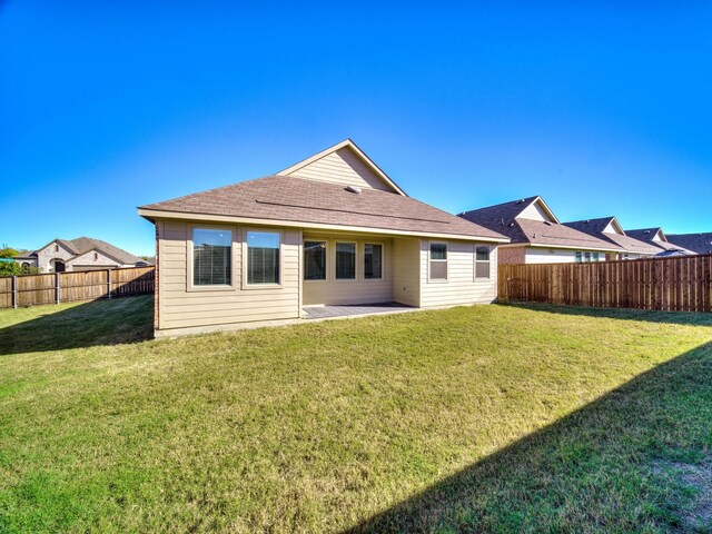 rear view of house with a patio and a lawn