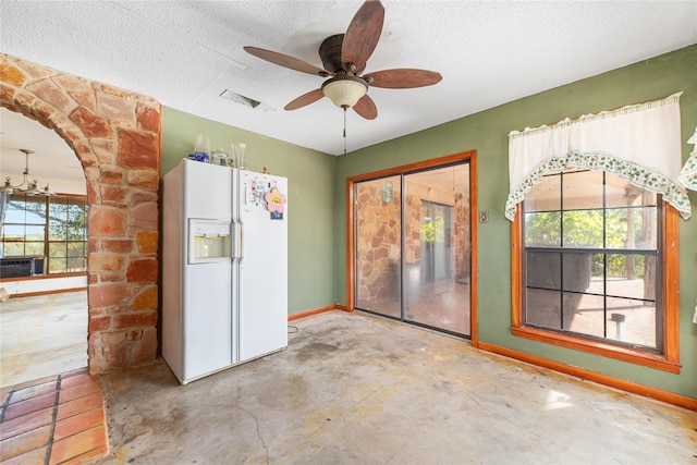 kitchen featuring ceiling fan with notable chandelier, cooling unit, white fridge with ice dispenser, a textured ceiling, and concrete floors