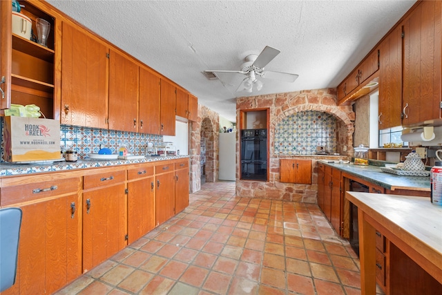 kitchen featuring decorative backsplash, a textured ceiling, double oven, and ceiling fan