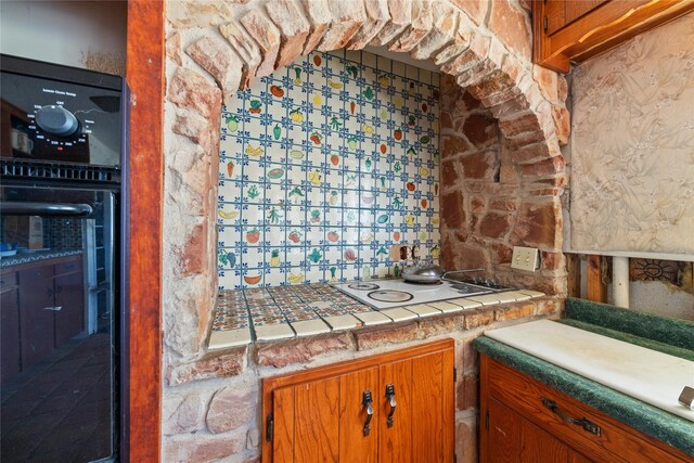 kitchen with tile countertops, oven, decorative backsplash, and white gas cooktop