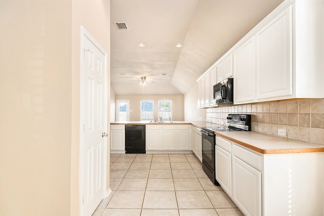 kitchen with lofted ceiling, black appliances, white cabinets, light tile patterned floors, and kitchen peninsula