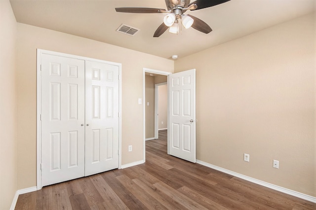 unfurnished bedroom featuring a closet, hardwood / wood-style flooring, and ceiling fan