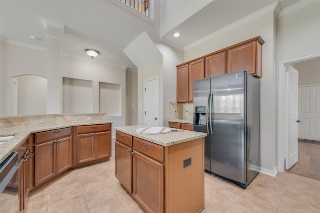 kitchen featuring decorative backsplash, light stone countertops, light tile patterned floors, a kitchen island, and stainless steel appliances