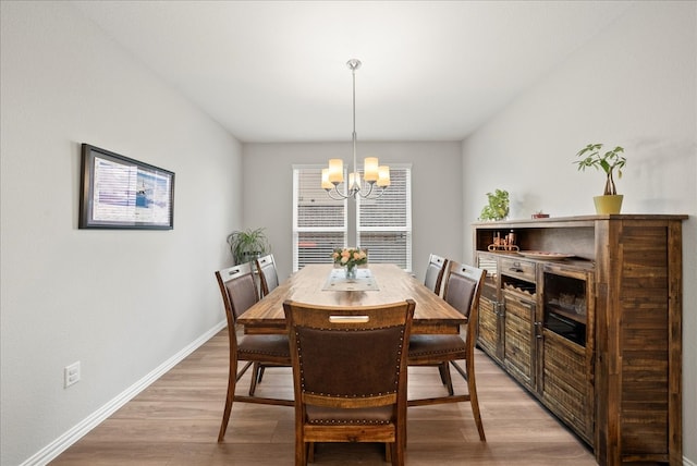 dining room featuring light hardwood / wood-style flooring and a notable chandelier