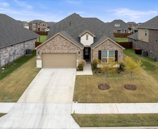 view of front of home with cooling unit, a garage, and a front yard