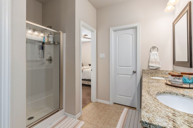 bathroom with tile patterned flooring, vanity, and walk in shower