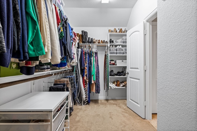 walk in closet featuring light colored carpet