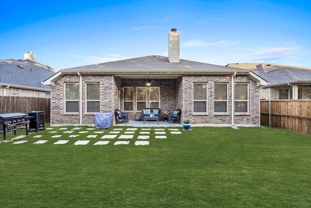 back of property with a lawn, outdoor lounge area, ceiling fan, and a patio area