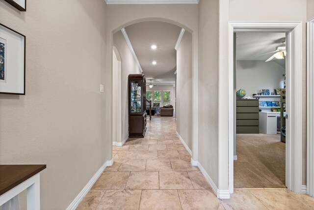 corridor featuring crown molding and light colored carpet