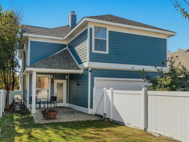 view of front of house with a front yard, a patio, and an outdoor fire pit