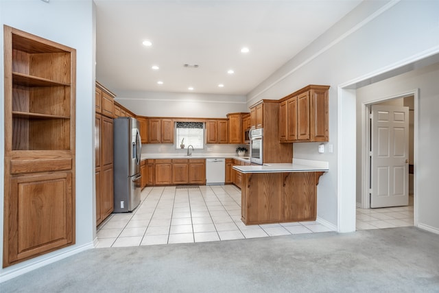 kitchen featuring kitchen peninsula, stainless steel fridge, light colored carpet, white dishwasher, and sink