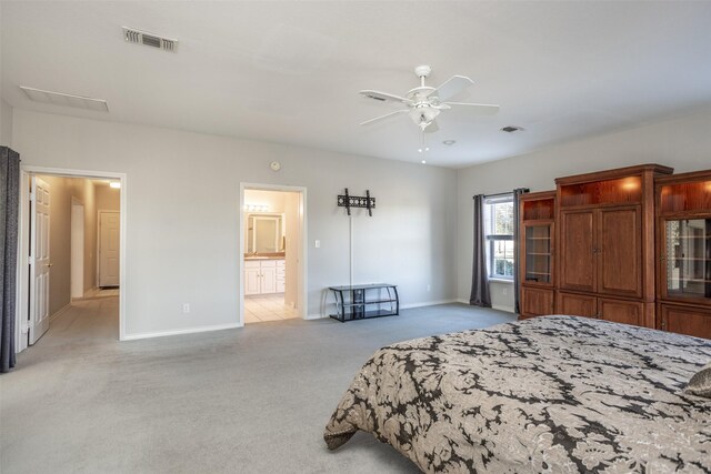 carpeted bedroom featuring ensuite bath and ceiling fan