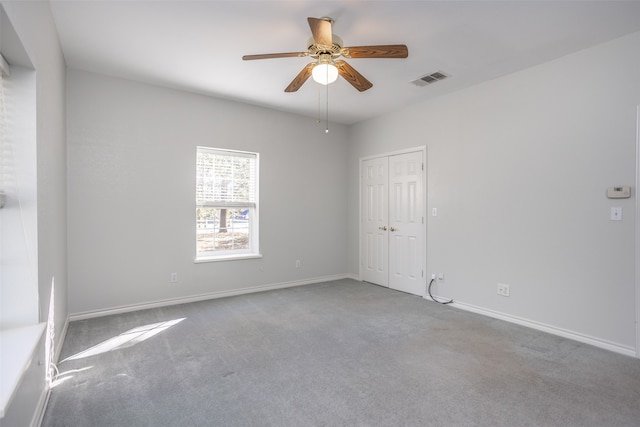 carpeted empty room featuring ceiling fan