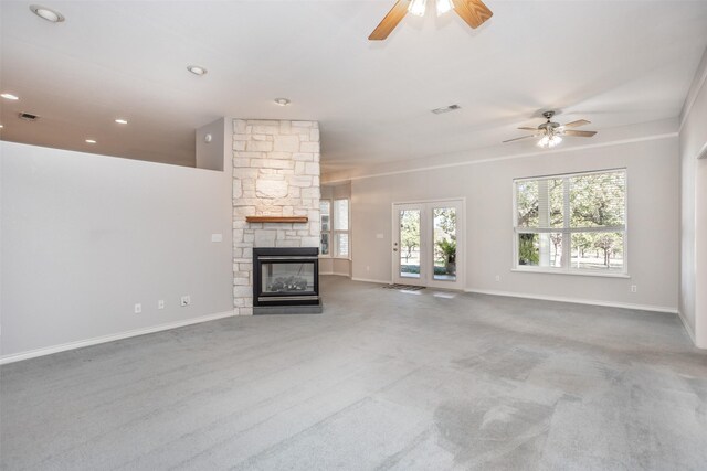 unfurnished living room featuring ceiling fan, carpet floors, and a fireplace