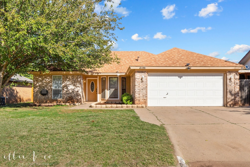 ranch-style home featuring a front yard and a garage