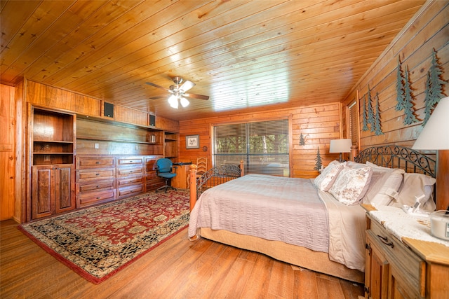 bedroom featuring wooden walls, hardwood / wood-style floors, ceiling fan, and wooden ceiling