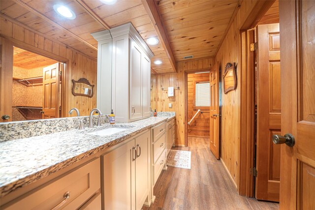 bathroom featuring vanity, hardwood / wood-style flooring, wood ceiling, and wood walls