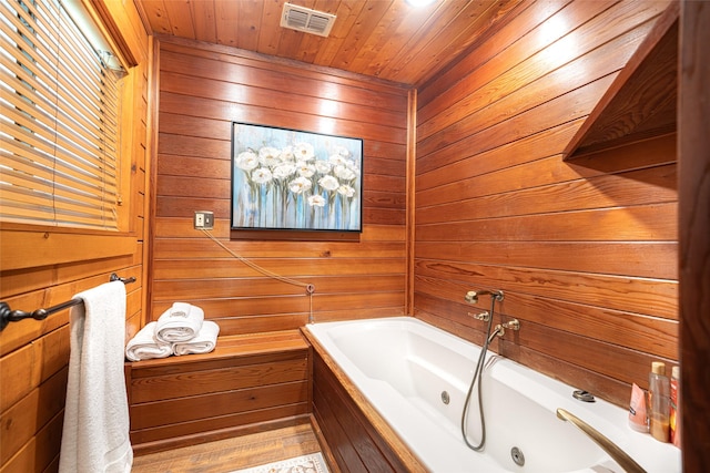 bathroom with a bathing tub, wood walls, wood ceiling, and hardwood / wood-style flooring