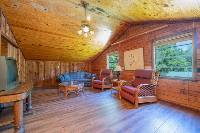 living room featuring hardwood / wood-style floors, vaulted ceiling, wooden ceiling, and wood walls